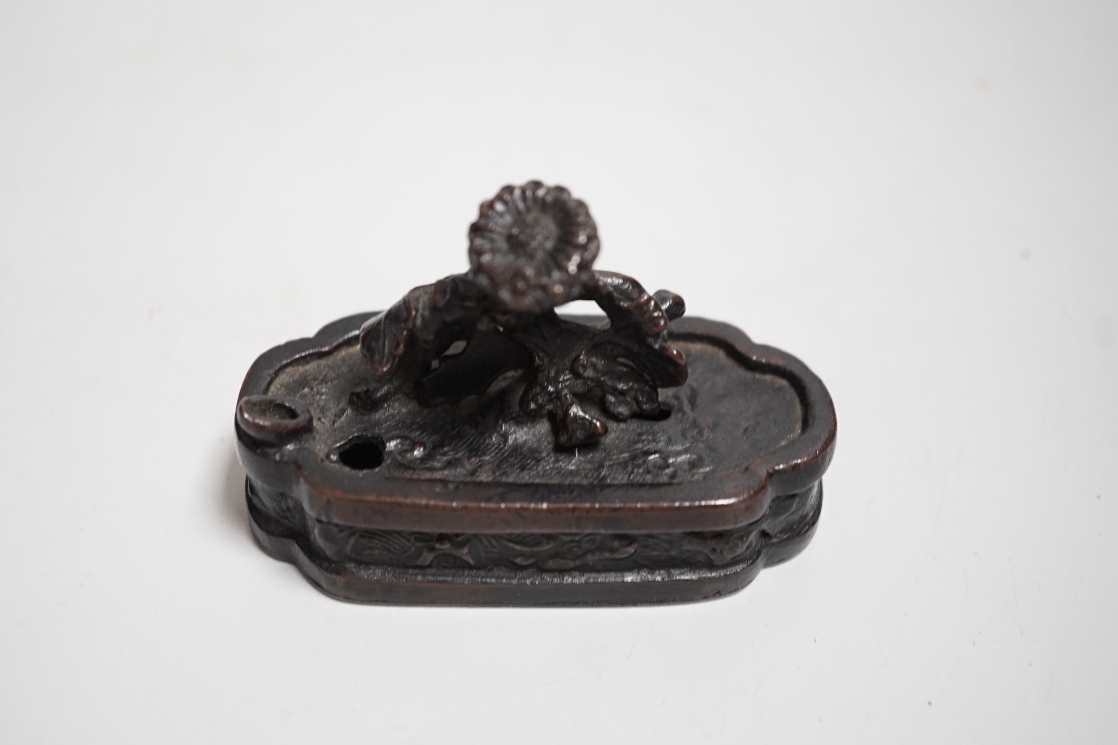 A Chinese bronze water-dropper of a flowering shrub in a jardiniere, 17th/18th century, 8cms wide